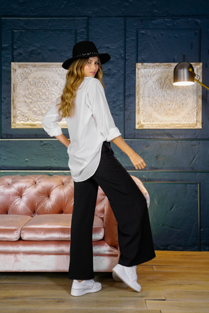 Camisa larga con pantalón negro y tenis.