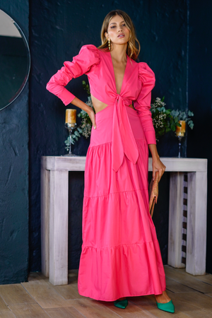 Vestido largo fucsia con cuello en V y tacones verdes.