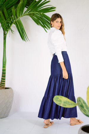 Falda larga en azul oscuro con camisa blanca y mangas puff.