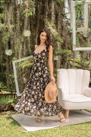 Vestido negro largo con tacones dorados.