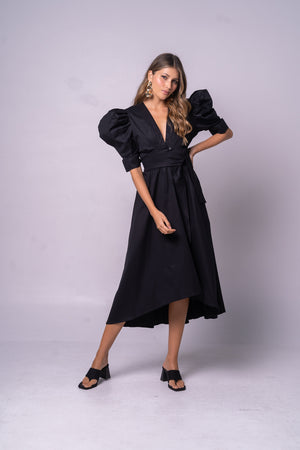 Vestido negro con cinturón y mangas con volumen.