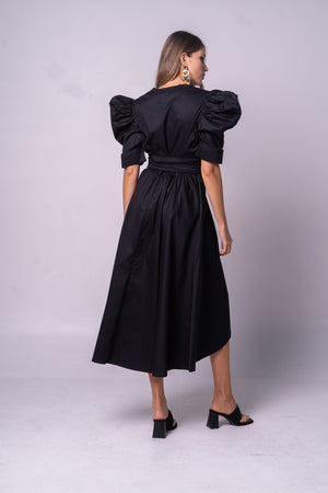 Vestido negro y elegante con manga puff y cinturón negro.