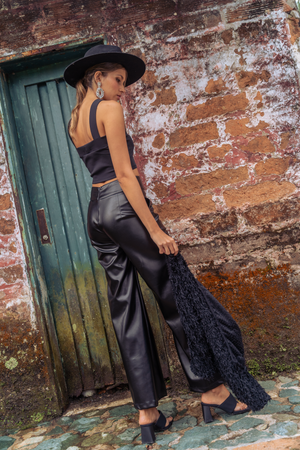 Pantalón cuero sintético con crop top y saco con textura
