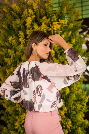 Blusa blanca con estampado neutro y pantalón rosado.