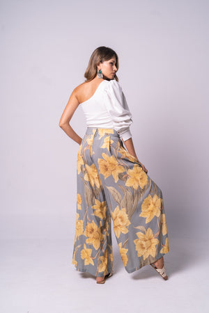 Pantalón tipo palazzo con blus asimétrica blanca.
