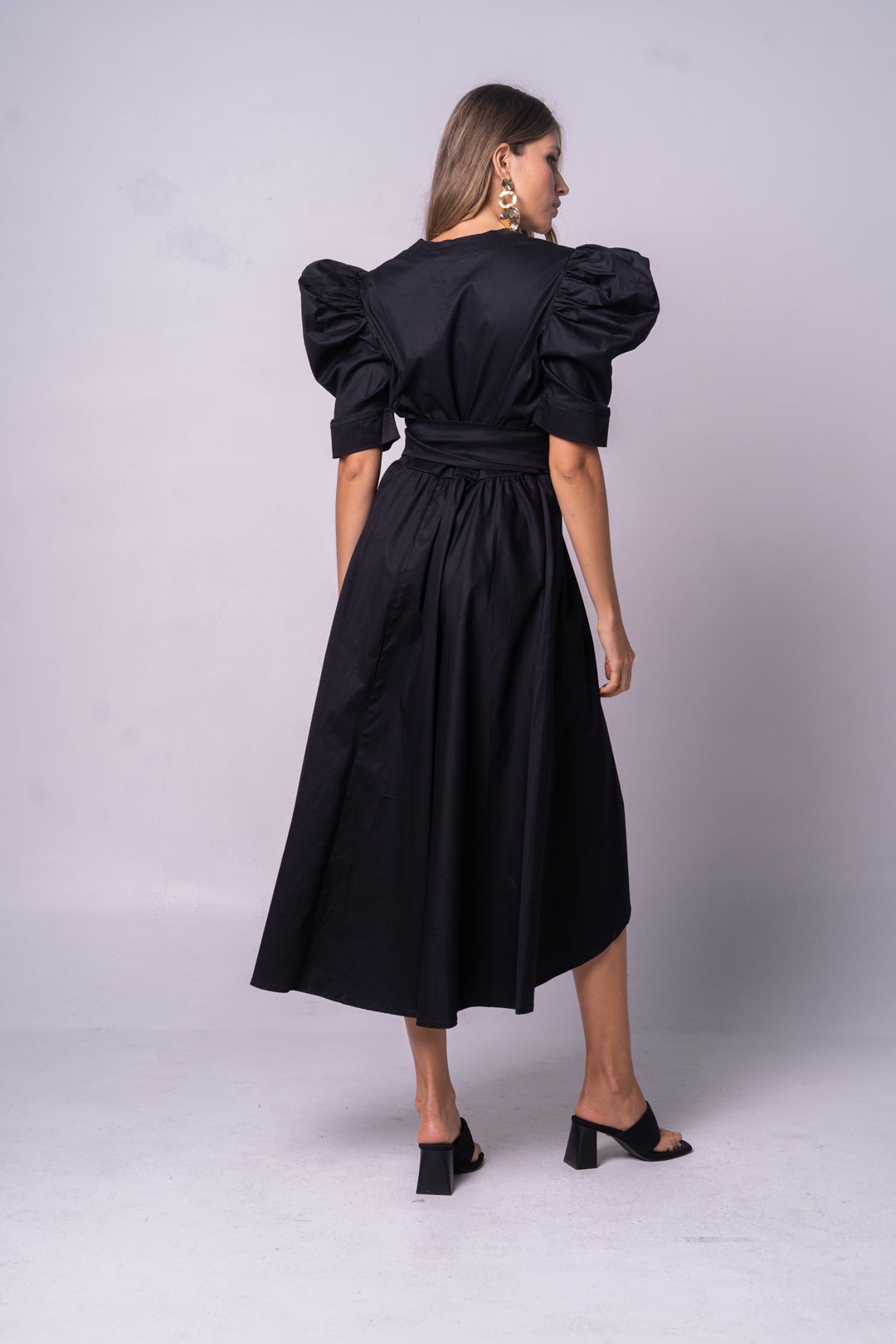 Vestido negro y elegante con manga puff y cinturón negro.