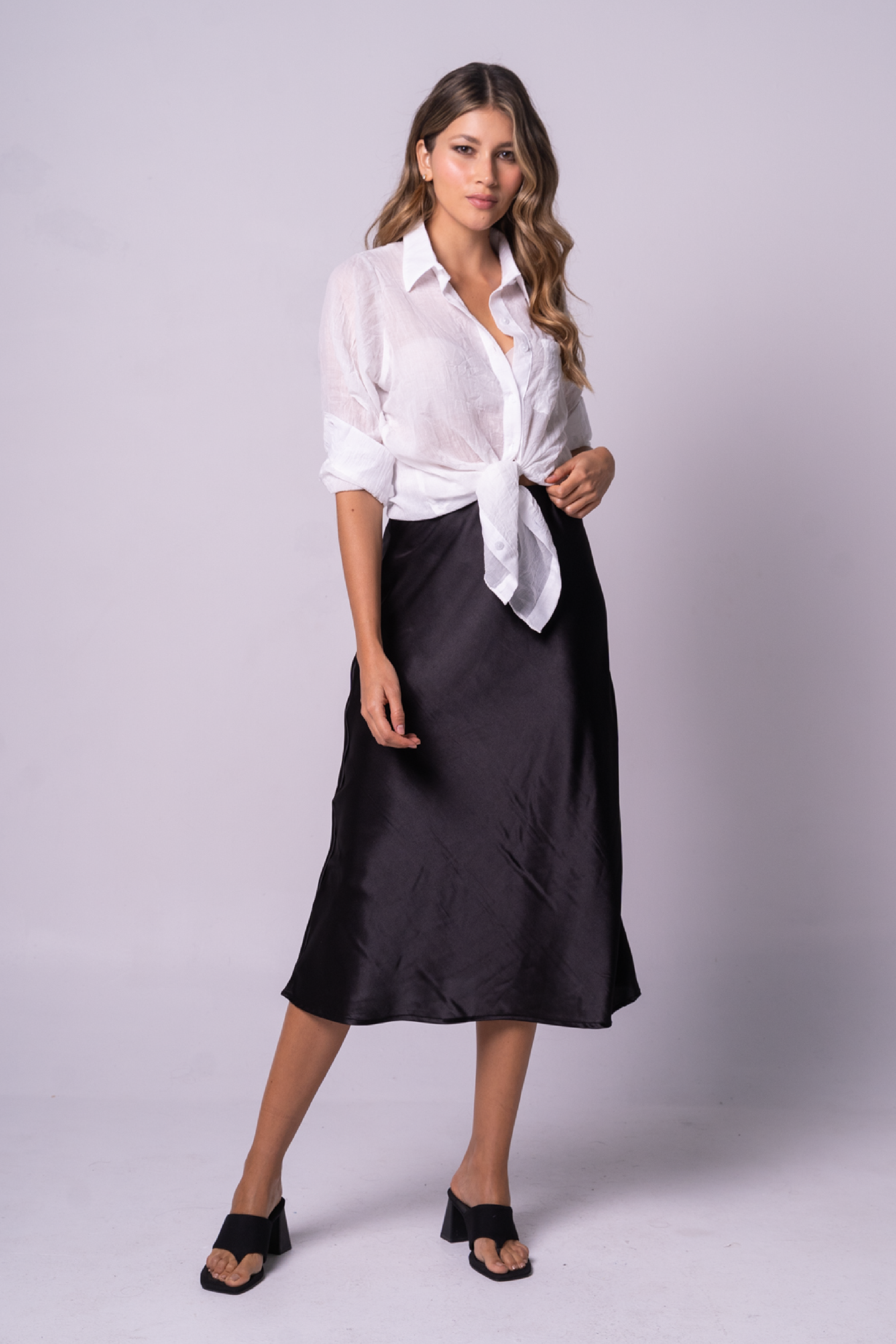 Falda mini satinada de color negro con blusa blanca